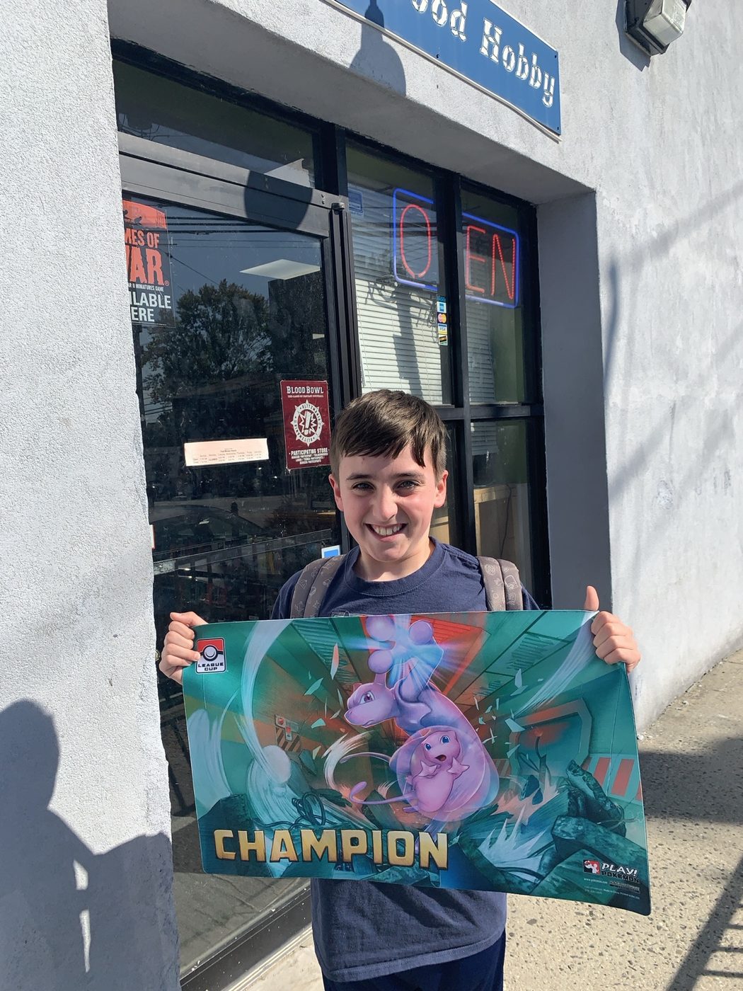 Charlie holding a Champion playmat after an early League Cup win